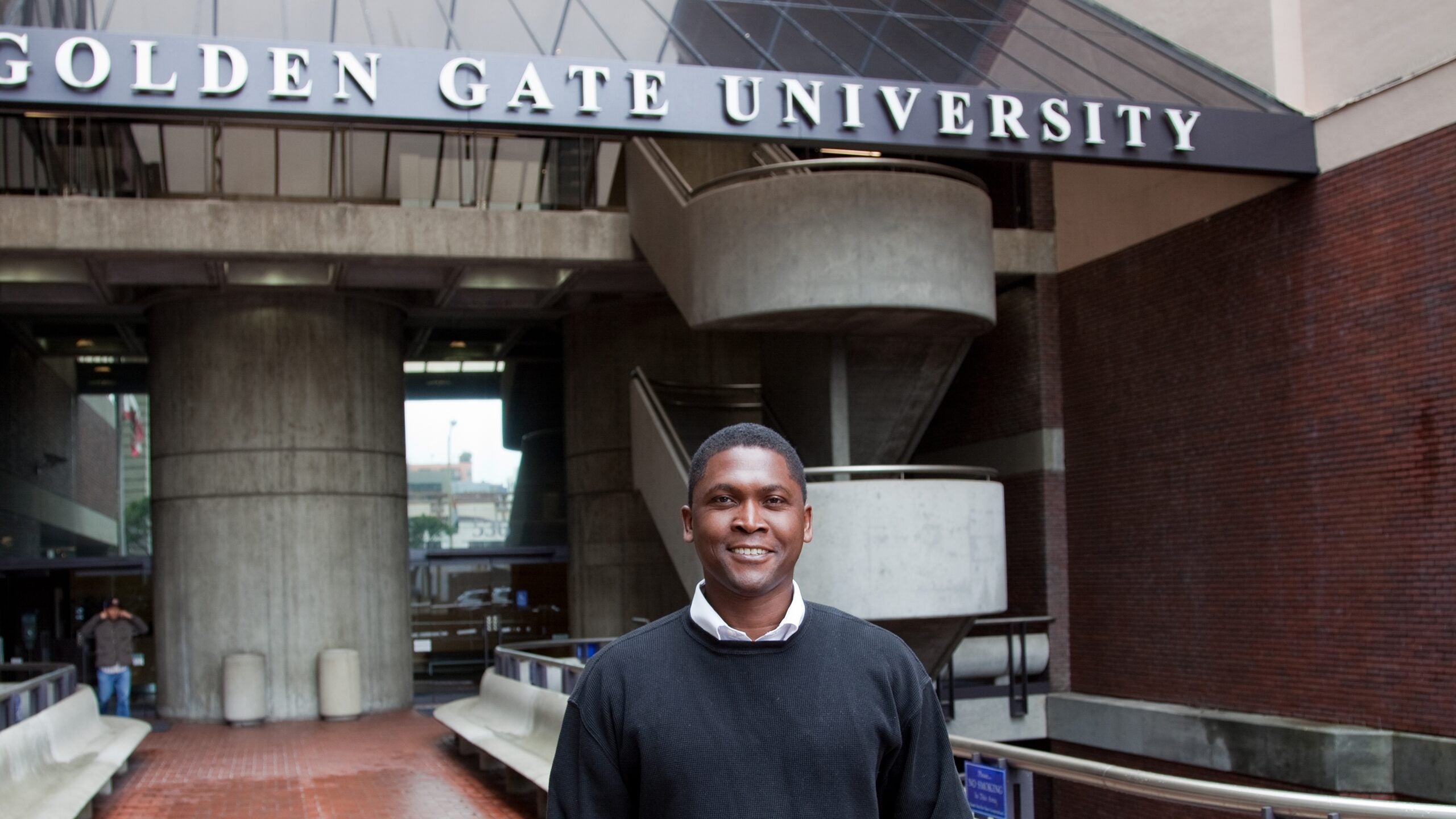 Student stands in front of Golden Gate University building.